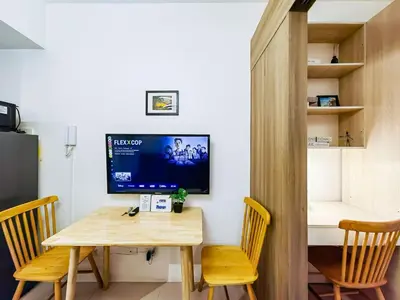 a dining room with a table and chairs and a television at 1BR Condotel with Balcony at FAME Residences #FM08-1 in Manila