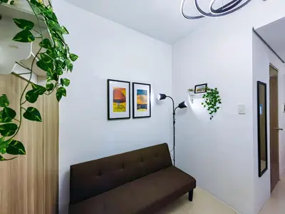 a living room with a couch and a lamp at 1BR Condotel with Balcony at FAME Residences #FM09-1 in Manila