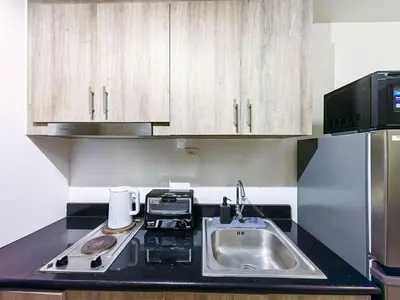 a small kitchen with a sink and a microwave at 1BR Condotel with Balcony at FAME Residences #FM09-1 in Manila