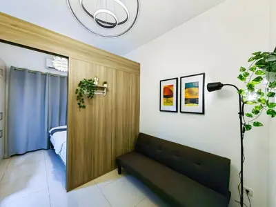 a living room with a couch and a bedroom at 1BR Condotel with Balcony at FAME Residences #FM09-1 in Manila