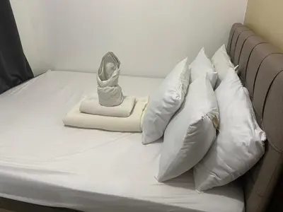 a bed with white pillows and a blanket at Ennu staycation Near Moa in Manila