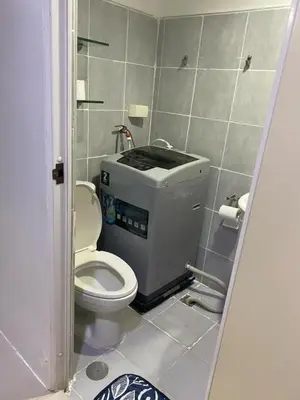 a small bathroom with a toilet in a stall at Ennu staycation Near Moa in Manila