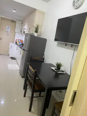 a kitchen with a black table and a refrigerator at Ennu staycation Near Moa in Manila