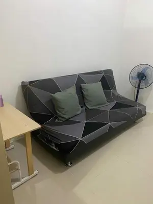 a black couch in a room with a table at Ennu staycation Near Moa in Manila