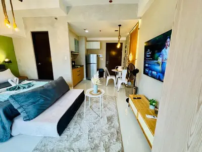 a bedroom with a large bed and a living room at Netflix and WiFi Staycation Viceroy Walk to Venice Grand Canal in Manila