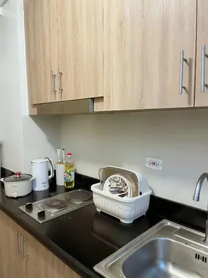 a kitchen with a sink and a counter top at On The Shores - Staycation in Manila