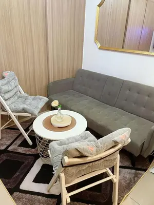 a living room with a couch and a table and chairs at On The Shores - Staycation in Manila