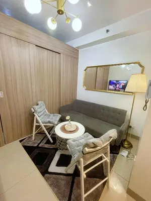 a living room with a couch and a table and chairs at On The Shores - Staycation in Manila