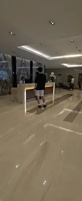 a person standing next to a bench in a lobby at Coast Residences in Manila
