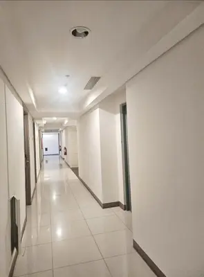 a hallway of an office building with white walls at Coast Residences in Manila