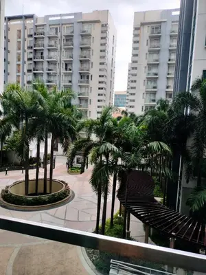 a balcony with palm trees in a city with buildings at Rqui Staycation Rooms Near Airports in Manila