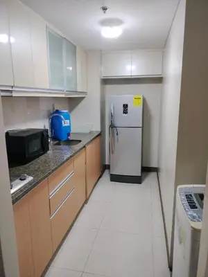 a kitchen with a refrigerator and a microwave at Rqui Staycation Rooms Near Airports in Manila