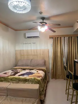 a bedroom with a bed and a ceiling fan at Alabang Staycation Sucat in Manila