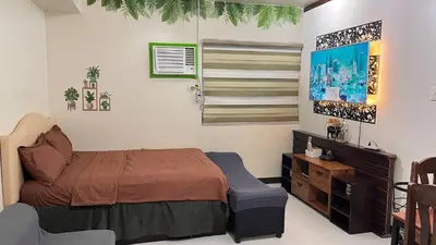 a bedroom with a bed and a tv in it at Alabang Staycation Sucat in Manila