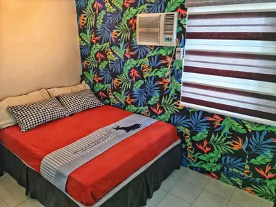 a small bed in a room with a wall at Alabang Staycation Sucat in Manila