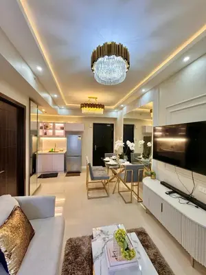 a living room with a white couch and a chandelier at Manila Bay Suite near PICC in Manila