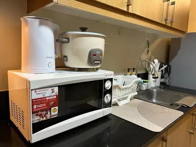 a coffee maker on top of a microwave on a kitchen counter at Vista gracia staycation in Manila