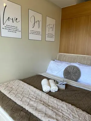 a bed with two white towels on it with pictures on the wall at Vista gracia staycation in Manila