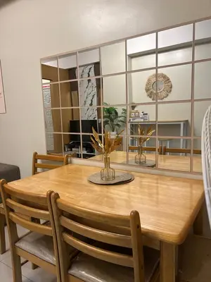 a dining room with a wooden table and chairs at Vista gracia staycation in Manila