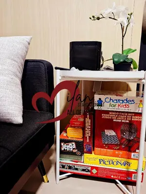 a table next to a chair and a table with a pile of food at Mall of Asia Sea Residences- Milan Staycations Casa Juan in Manila
