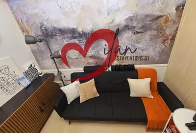 a living room with a couch with a red ribbon at Mall of Asia Sea Residences- Milan Staycations Casa Juan in Manila