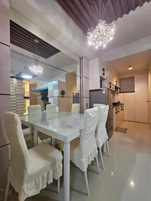 a dining room with a white table and white chairs at Sea Residences Mall of Asia Viann in Manila