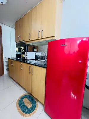 a kitchen with a red refrigerator in a room at Sea Residences Mall of Asia Viann in Manila
