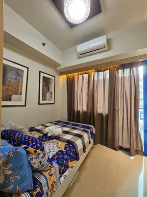 a bedroom with two beds and a window at Sea Residences Mall of Asia Viann in Manila
