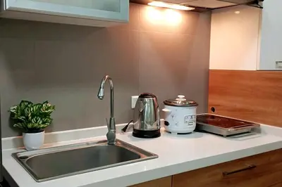 a kitchen counter with a sink and a appliance at Cozy Condo near BGC and Ortigas with free Gym & Pool in Manila