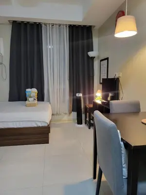 a bedroom with a bed and a desk and a table at Cozy Condo near BGC and Ortigas with free Gym & Pool in Manila