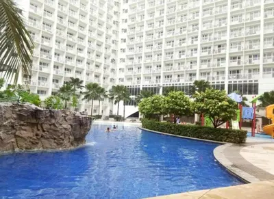 a swimming pool in front of a large building at MOA staycation located in Shore1 and 2 Residences Pasay City in Manila