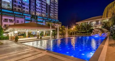 a large swimming pool in front of a building at night at MOA staycation located in Shore1 and 2 Residences Pasay City in Manila