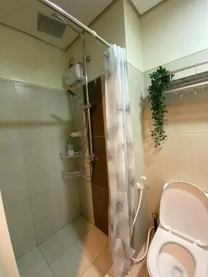 a bathroom with a toilet and a shower at Cozy Staycation in Pasay in Manila