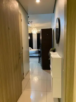 a hallway with a refrigerator and a bedroom at Cozy Staycation in Pasay in Manila
