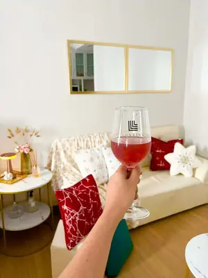 a person holding a glass of wine in a living room at LuxeInn in Trece Martires
