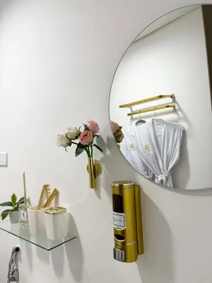 a bathroom with a mirror and a vase with flowers at LuxeInn in Trece Martires