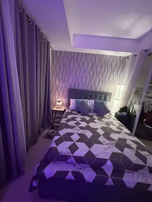 a bedroom with a large bed with purple lighting at 1BR Condotel in Azure Urban Resort Near NAIA #TRO3 in Manila