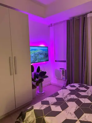 a purple room with a bed and a tv at 1BR Condotel in Azure Urban Resort Near NAIA #TRO3 in Manila