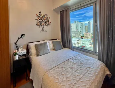 a bedroom with a bed and a large window at 8 Adriatico Manila in Manila