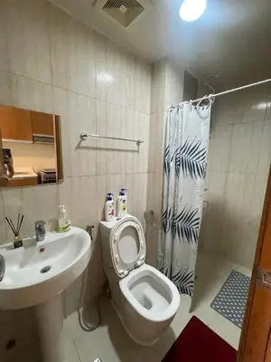 a bathroom with a toilet and a sink and a shower at 8 Adriatico Manila in Manila
