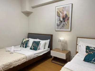 a bedroom with two beds and a night stand at 8 Adriatico Manila in Manila
