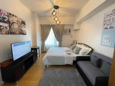 a bedroom with a bed and a tv and a couch at 8 Adriatico Manila in Manila