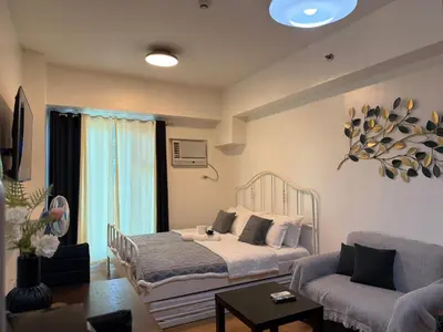 a living room with a bed and a couch at 8 Adriatico Manila in Manila