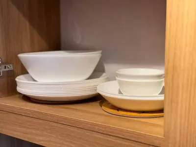 a stack of bowls and plates on a shelf at 4BR Townhouse w Garage, Peaceful near Restaurants in Manila