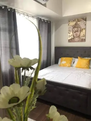 a bedroom with a bed with yellow pillows and a window at Apartment in quezon city in Manila