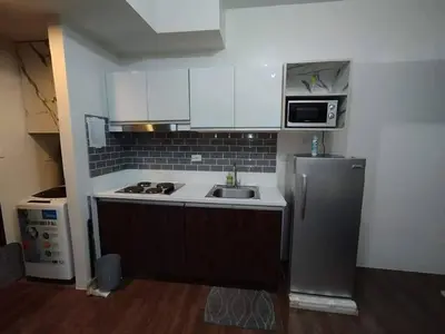 a small kitchen with a sink and a microwave at Apartment in quezon city in Manila