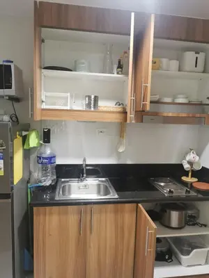 a kitchen with a sink and a refrigerator at Mall of Asia condotel shore 3 residence in Manila