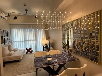 a living room with a dining table and a chandelier at Modern 1BR with Balcony Facing Infinity Pool Manila Bay Sunset Near Airports OKADA Solaire MOA in Manila