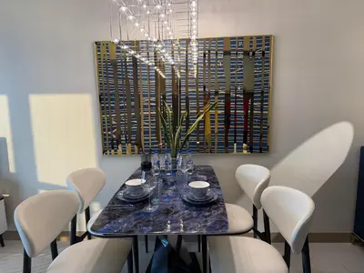 a dining room with a table and white chairs at Modern 1BR with Balcony Facing Infinity Pool Manila Bay Sunset Near Airports OKADA Solaire MOA in Manila