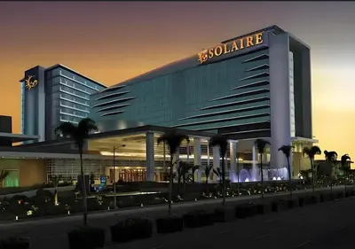 a large building with a gold sign on it at Modern 1BR with Balcony Facing Infinity Pool Manila Bay Sunset Near Airports OKADA Solaire MOA in Manila